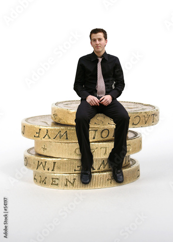 business man sitting on coins business man sitting on coins