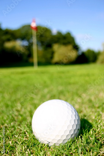 balle de golf davant drapeau