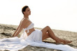 woman in white clothes sitting on the beach