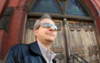 man in sunglasses in front of the church