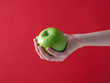 apple in hand on red