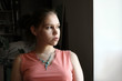 unhappy teenage girl  by the window