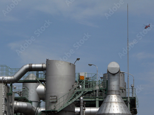 industrial factory with flying helicopter above
