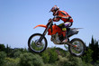 red and orange moto x or motor cross bike giving big air on dirt