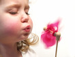 Foto: girl blowing pinwheel girl blowing pinwheel