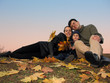 family with autumn leaves and sunset