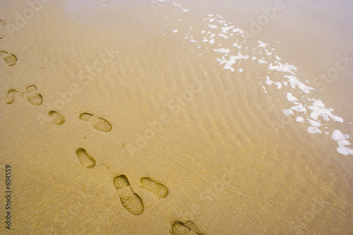 man and boy's footprints in the sand