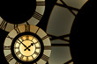gold clockface surrounded by parts of roman numeral clockfaces
