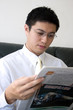 young asian entrepreneur reading newspaper