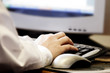 hand typing at a computer