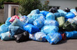 garbage bags by a city street. garbage bags by a city street.