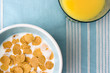 plate of breakfast cereal and glass of orange juic