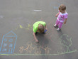 children drawing on asphalt family house