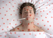man with red spots on face and body