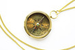 old style gold compass with chain on white backgro