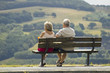 two older people sitting on a bench