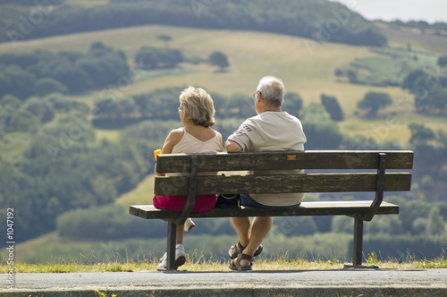two older people sitting on a bench