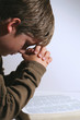 young boy praying over his bible young boy praying over his bible