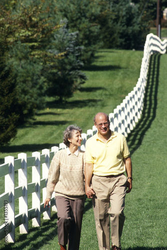 Photo: couple walking a white fence in the country couple walking a white fence in the country