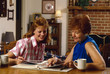 young wife and mother-in-law look through photo al