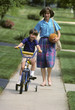 mother helps son learn to ride a bike