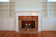 lit fireplace with built in bookshelves