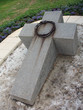 stone orthodox cross with a thorny wreath made of iron
