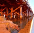 wooden support of pier bridge over river and rock wooden support of pier bridge over river and rock