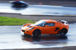 orange sports car on wet race circuit orange sports car on wet race circuit