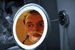 man shaving in mirror