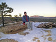 hiker taking a brake on top of a cliff
