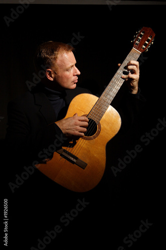 Photo: man playing a guitar man playing a guitar
