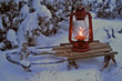 oil lamp on an old sled in snowy winter evening