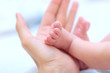 man hold baby leg in hand