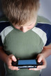 boys hand playing portable video game
