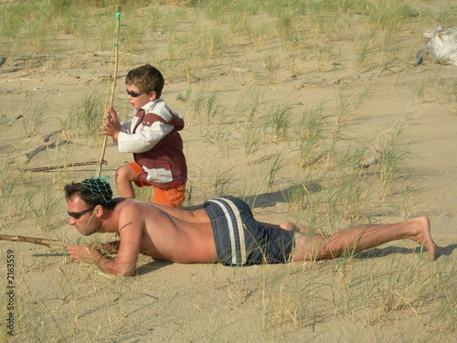 Photo: père et fils jouant aux aventuriers sur la plage père et fils jouant aux aventuriers sur la plage