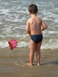 jeune garçon avec une épuistte au bord de l'eau