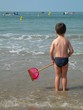jeune garçon avec une épuistte au bord de l'eau