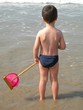 jeune garçon avec une épuisette au bord de l'eau