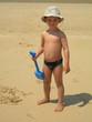 jeune garçon sur la plage avec une pelle