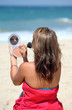 young tanned woman putting make up on whilst on th