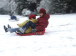 geschwister beim rodeln im schnee