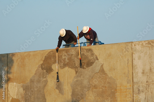 construction workers cleaning cement wall construction workers cleaning cement wall
