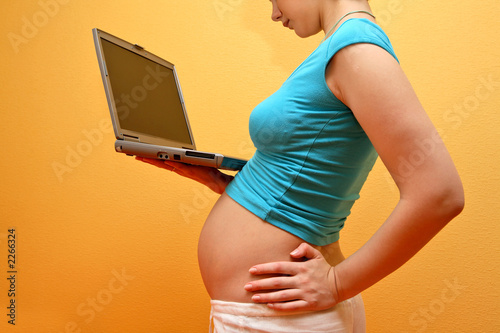Photo: happy pregnancy - pregnant woman browsing on inter happy pregnancy - pregnant woman browsing on inter