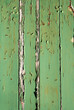 flaking green paint on a wooden fence.