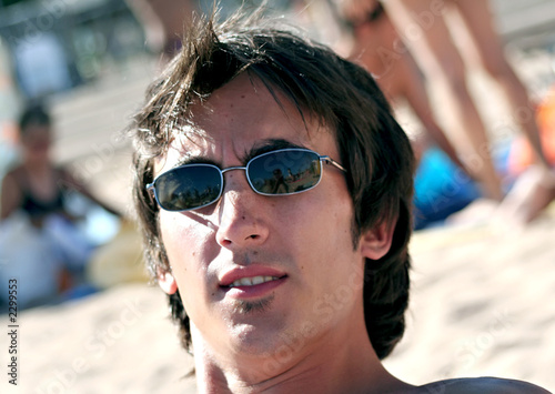 Photo: jeune homme avec lunettes de soleil bronzé plage jeune homme avec lunettes de soleil bronzé plage