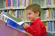 Photo: boy reading book at the library boy reading book at the library