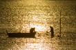 two fisherman in water with back light