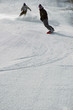 two snowboarders carving