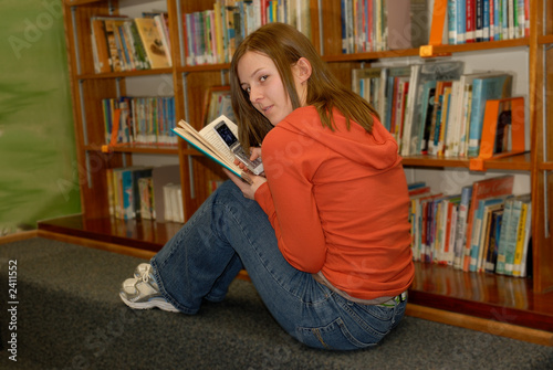 Photo: teenager in library 2 with cell phone teenager in library 2 with cell phone